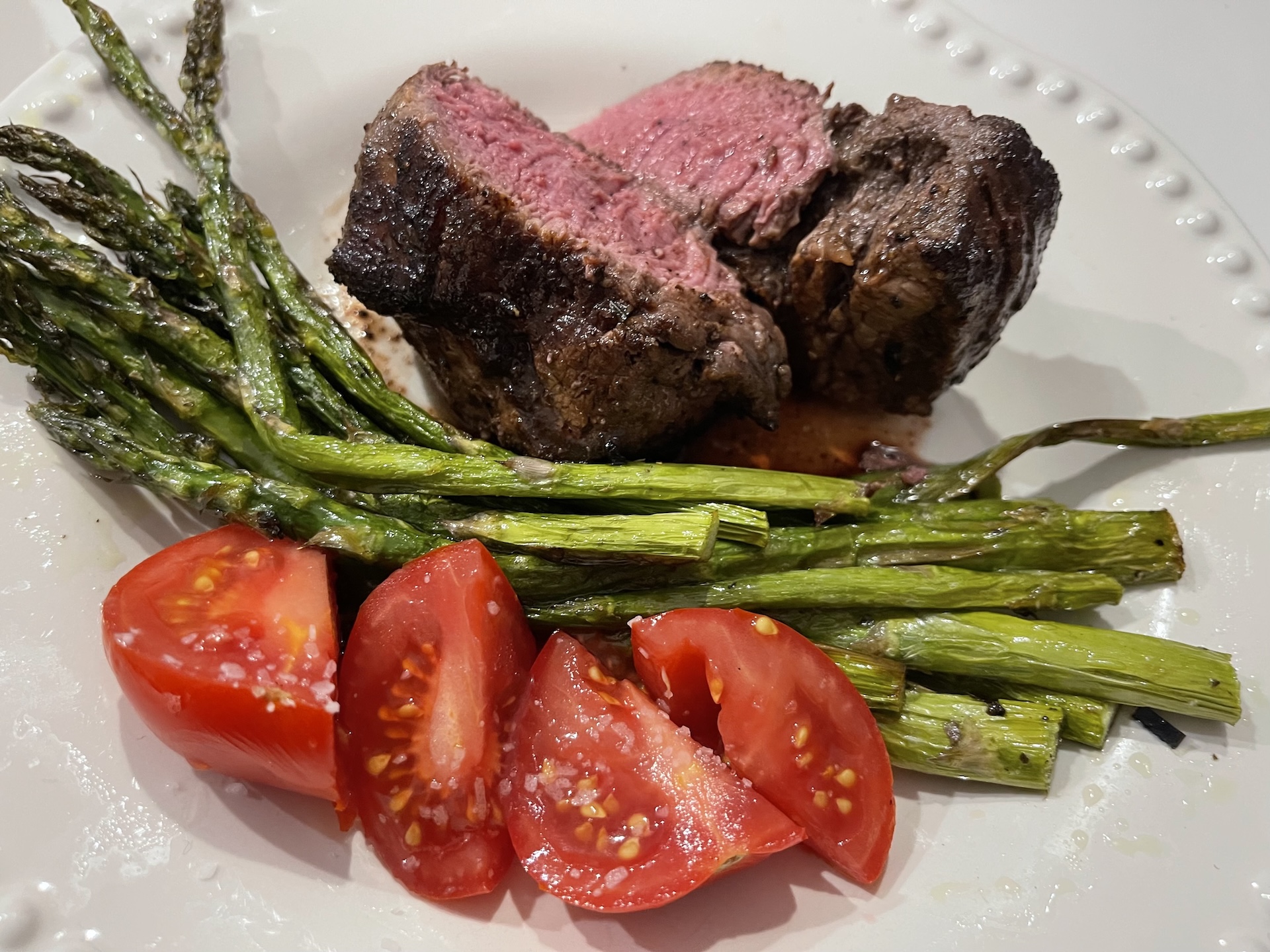 Plated filet with asparagus and tomato — editorial culinary still by Lisa Redman